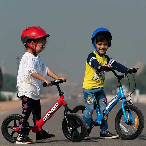 Two kids ride Strider bikes in India