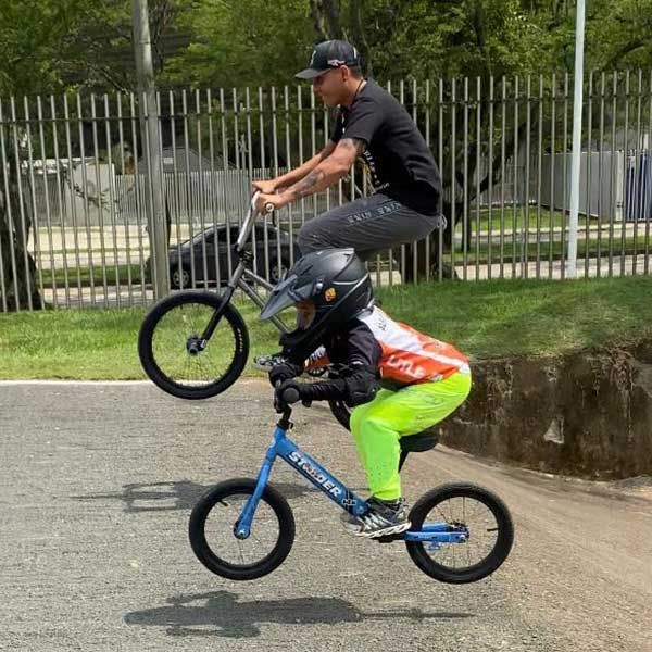 Adult and child jumping bikes at a BMX park