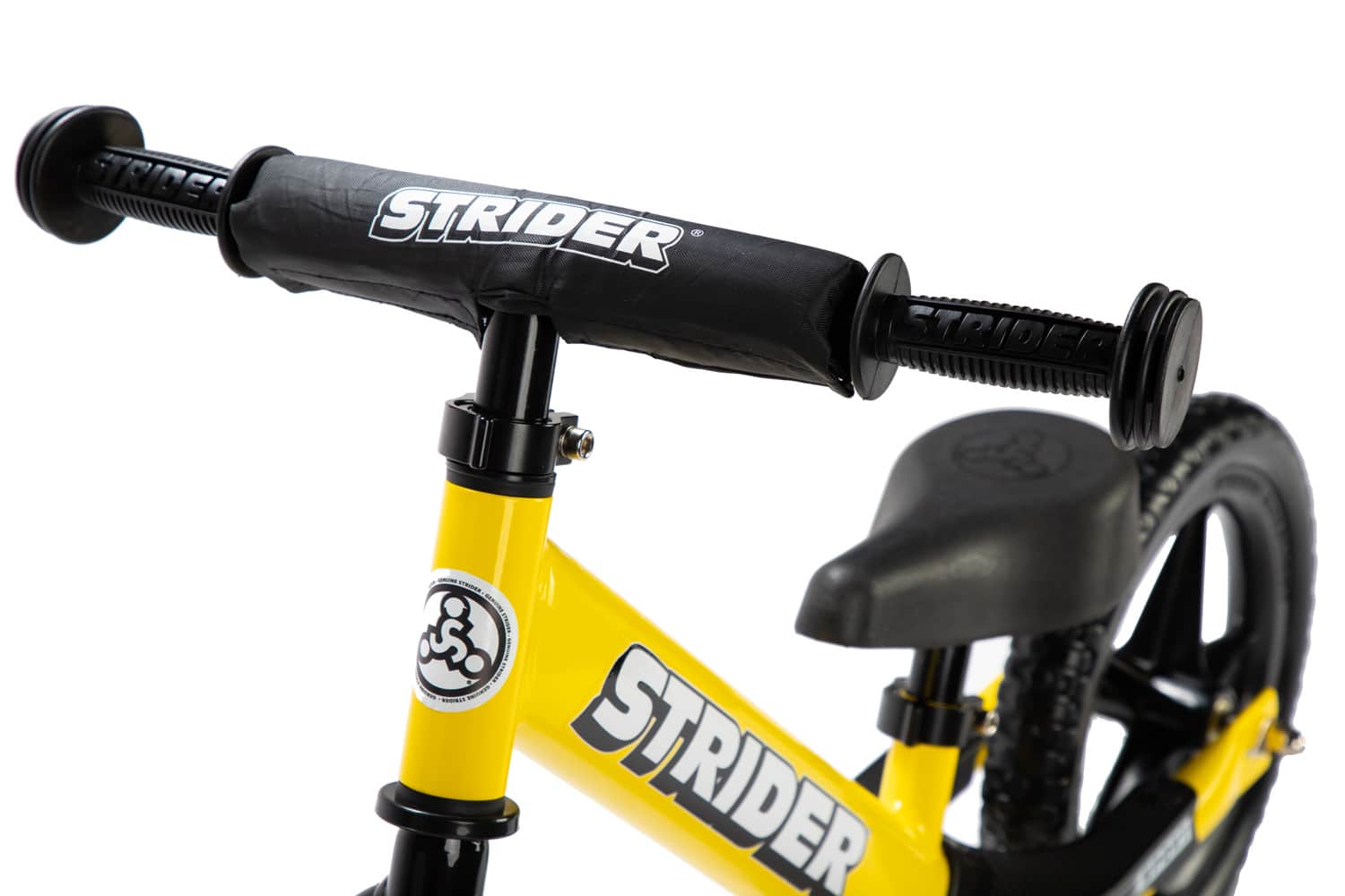 Studio detail of handlebar and grips on a yellow Strider 12 Sport balance bike