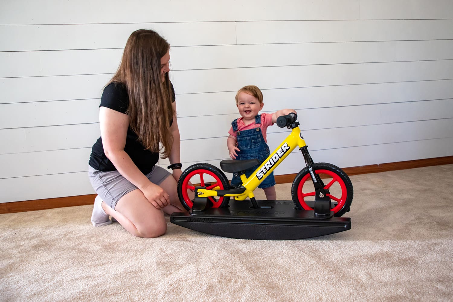 Mother, baby, and yellow Strider Sport Rocking Bike