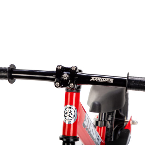 Studio image of Strider Aluminum Flat Handlebar with Grips on red 12 Sport - close-up angled view