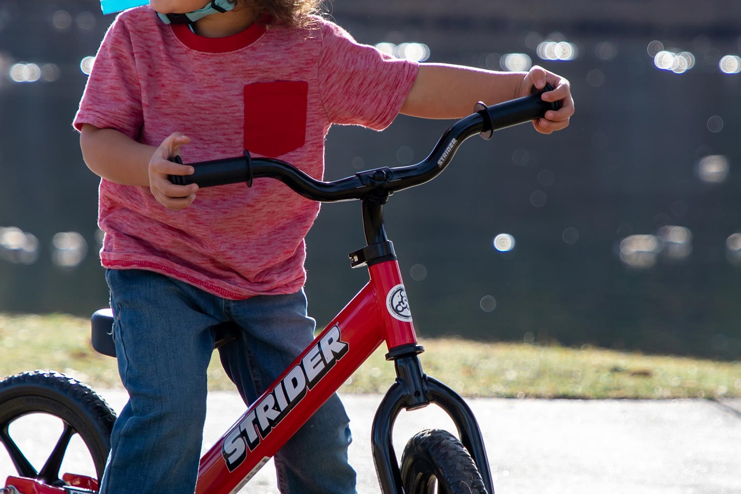 Close up photo of a Strider Standard Stem in use on a red balance bike